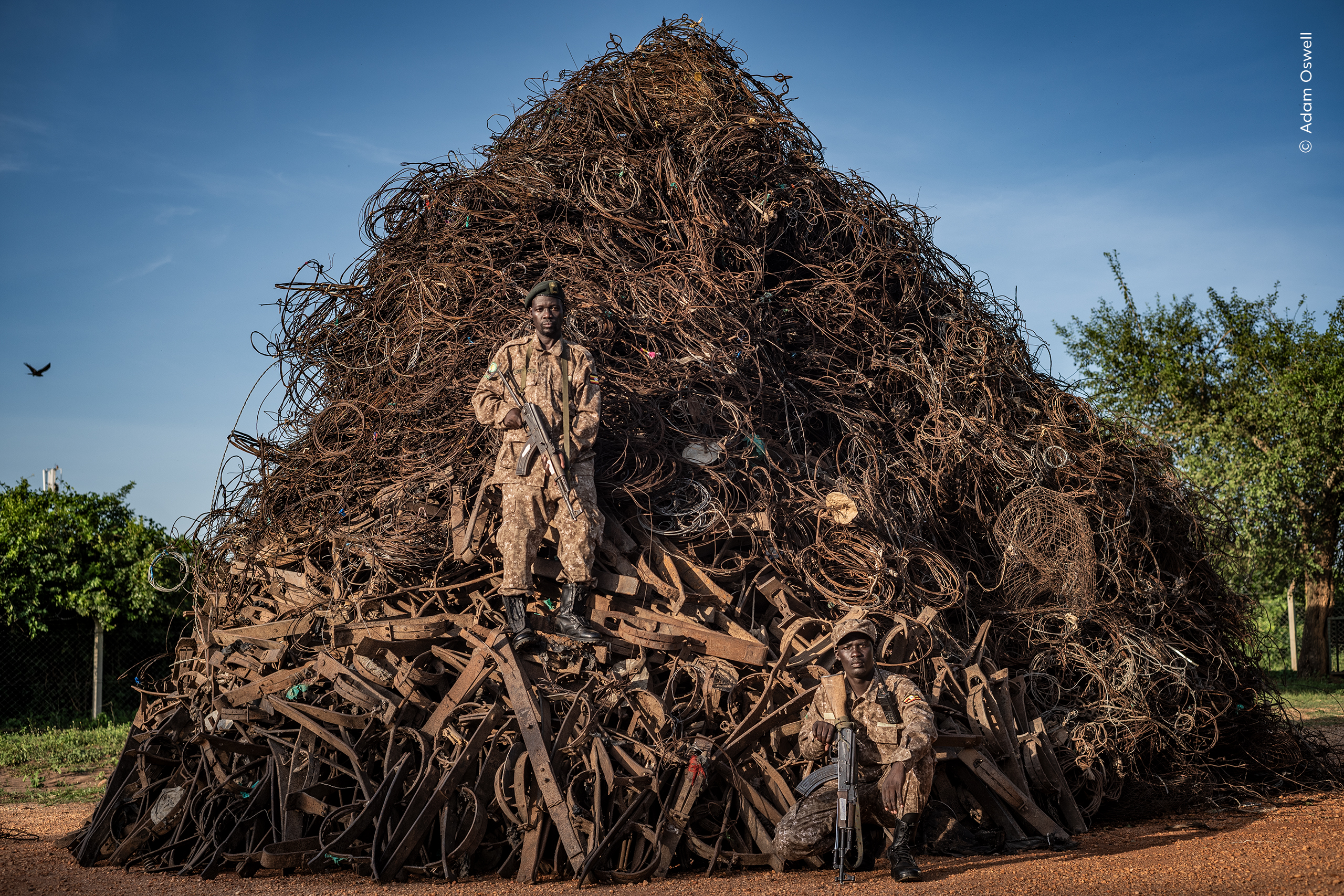 Uganda Wildlife Authority rangers stand before a mountain of confiscated snares.