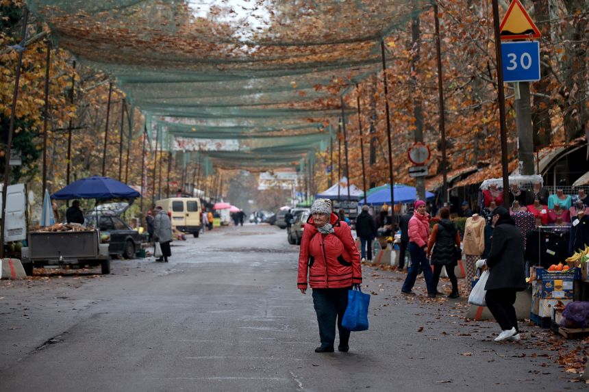 People visit a farmers' market set up in a street sealed off by anti-drone nets to safeguard from Russian drones in frontline Kherson, Ukraine, on November 11, 2025.