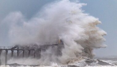 Waves crash over Blyth Pier lighthouse in Northumberland during Storm Chandra last month. Pic: AP
