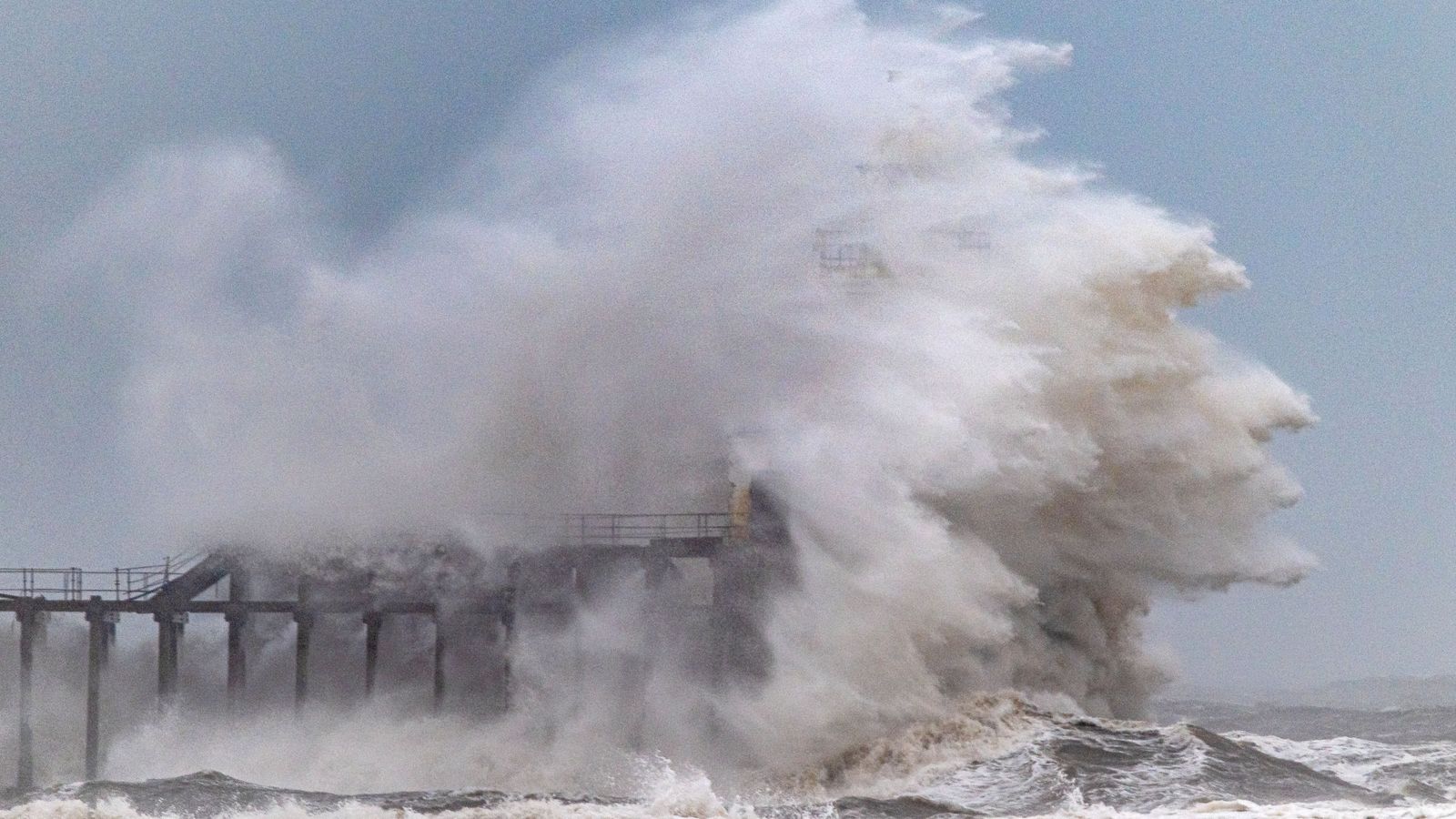 Waves crash over Blyth Pier lighthouse in Northumberland during Storm Chandra last month. Pic: AP