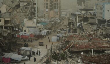 Palestinians walk along a street surrounded by buildings destroyed in recent Israeli air and ground operations. Pic: AP