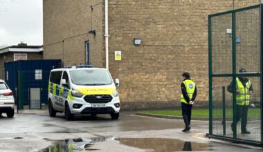 A police vehicle and security guards at Kingsbury High School on Wednesday. Pic: PA