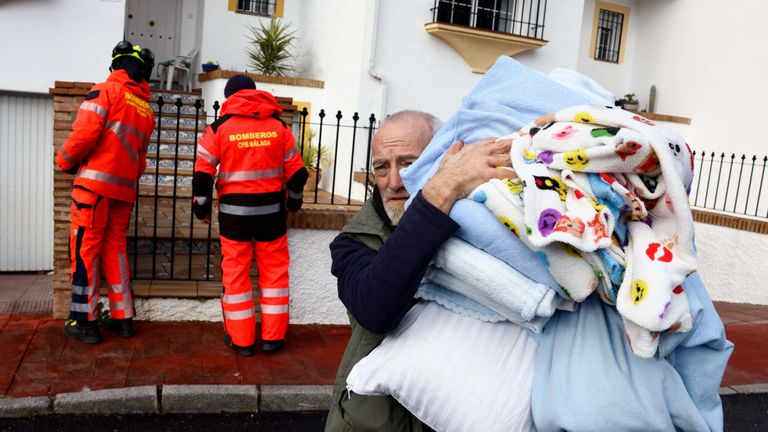 A resident carries his belongings after he is evacuated from his home. Pic: Reuters