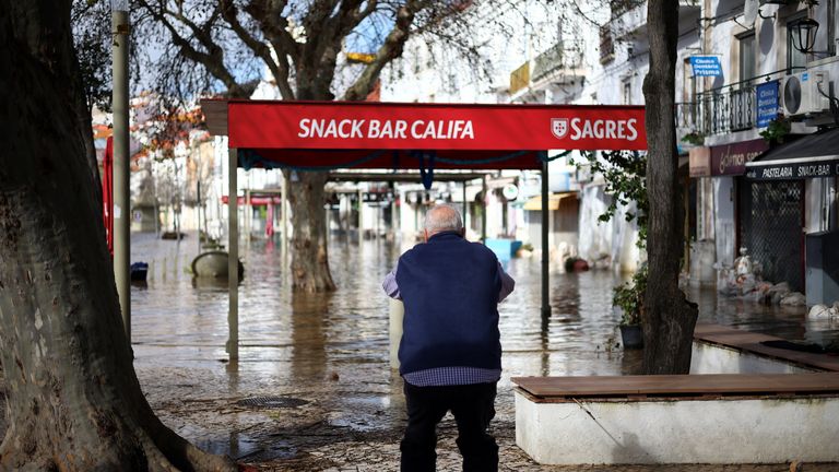 A person takes a picture of flooded streets. Pic: Reuters