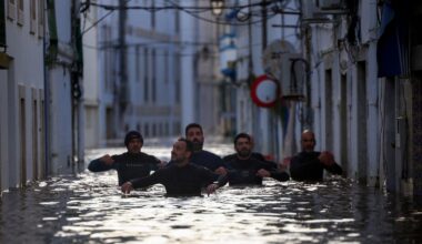 Volunteers wade through a flooded street in Alcacer do Sal. Pic: Reuters