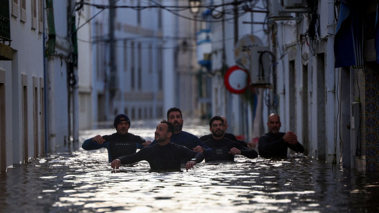 Volunteers wade through a flooded street in Alcacer do Sal. Pic: Reuters