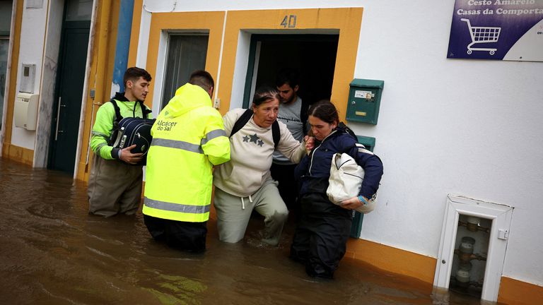 Volunteers help residents out of their homes in Alcacer do Sal, Portugal. Pic: Reuters