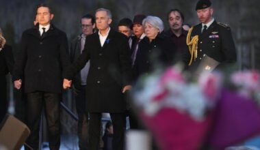 Prime Minister Carney and Canada's main opposition leader hold hands during school shooting vigil