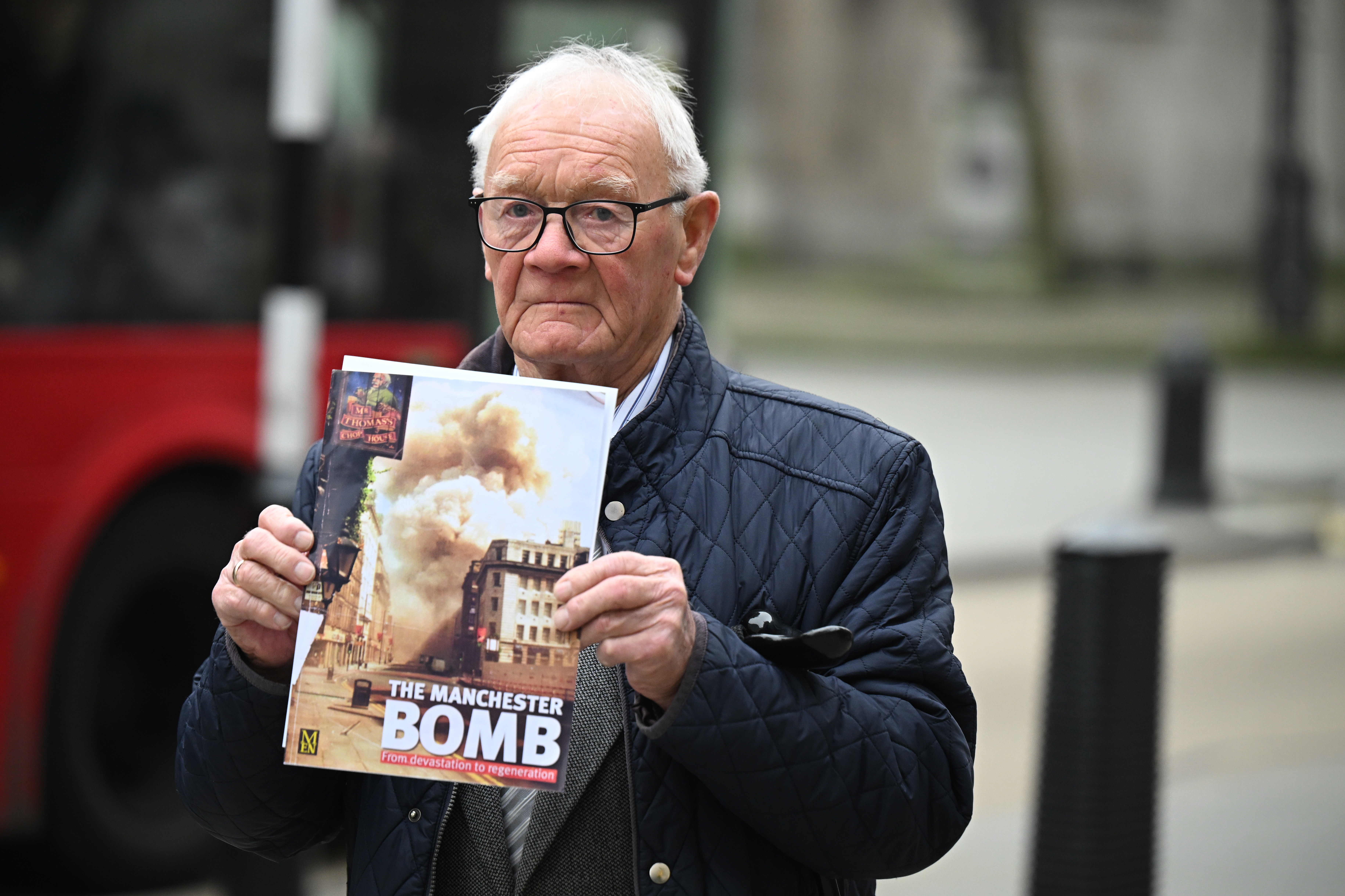 Barry Laycock holds a magazine with a cover image of "The Manchester Bomb."