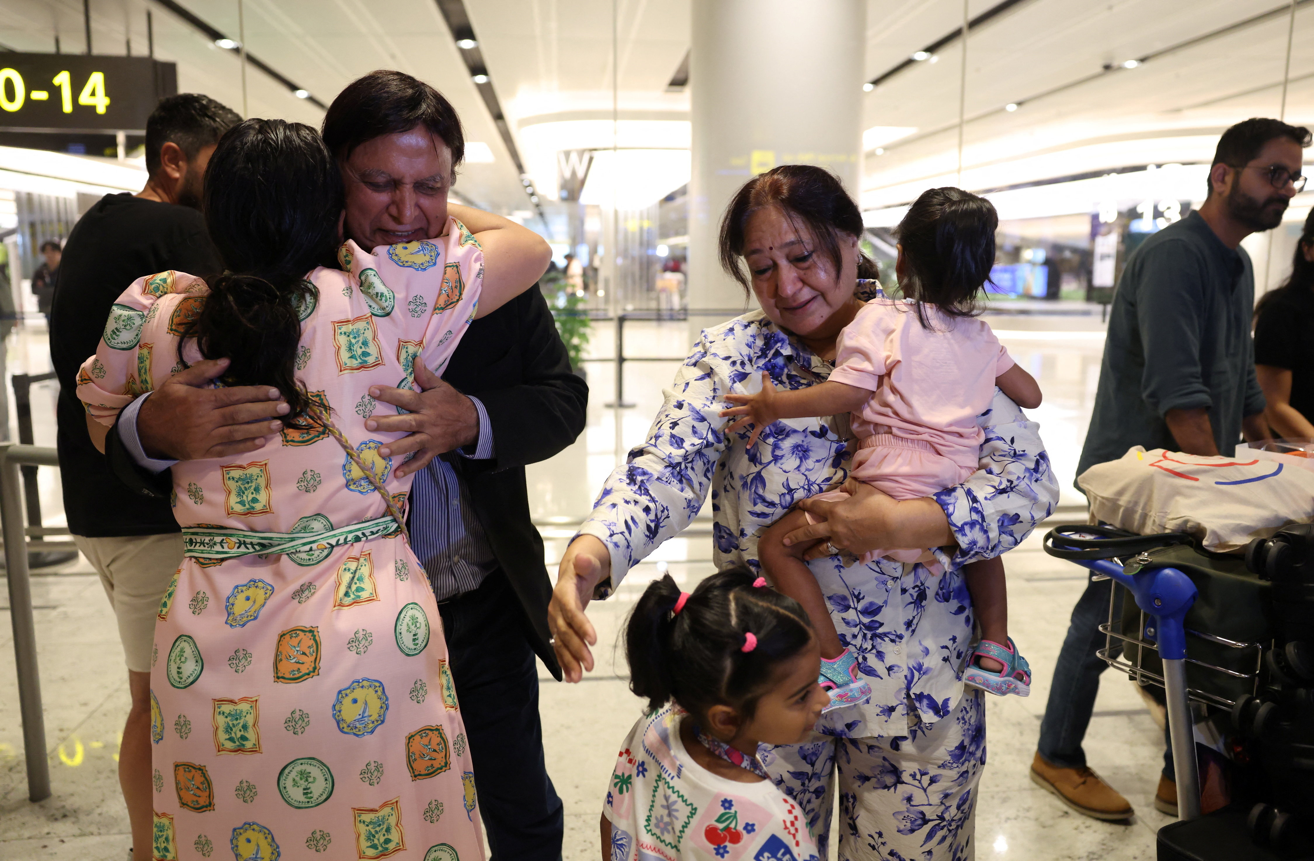 Ashoke Batura hugs his family upon returning to Singapore from the Middle East at Changi Airport in Singapore