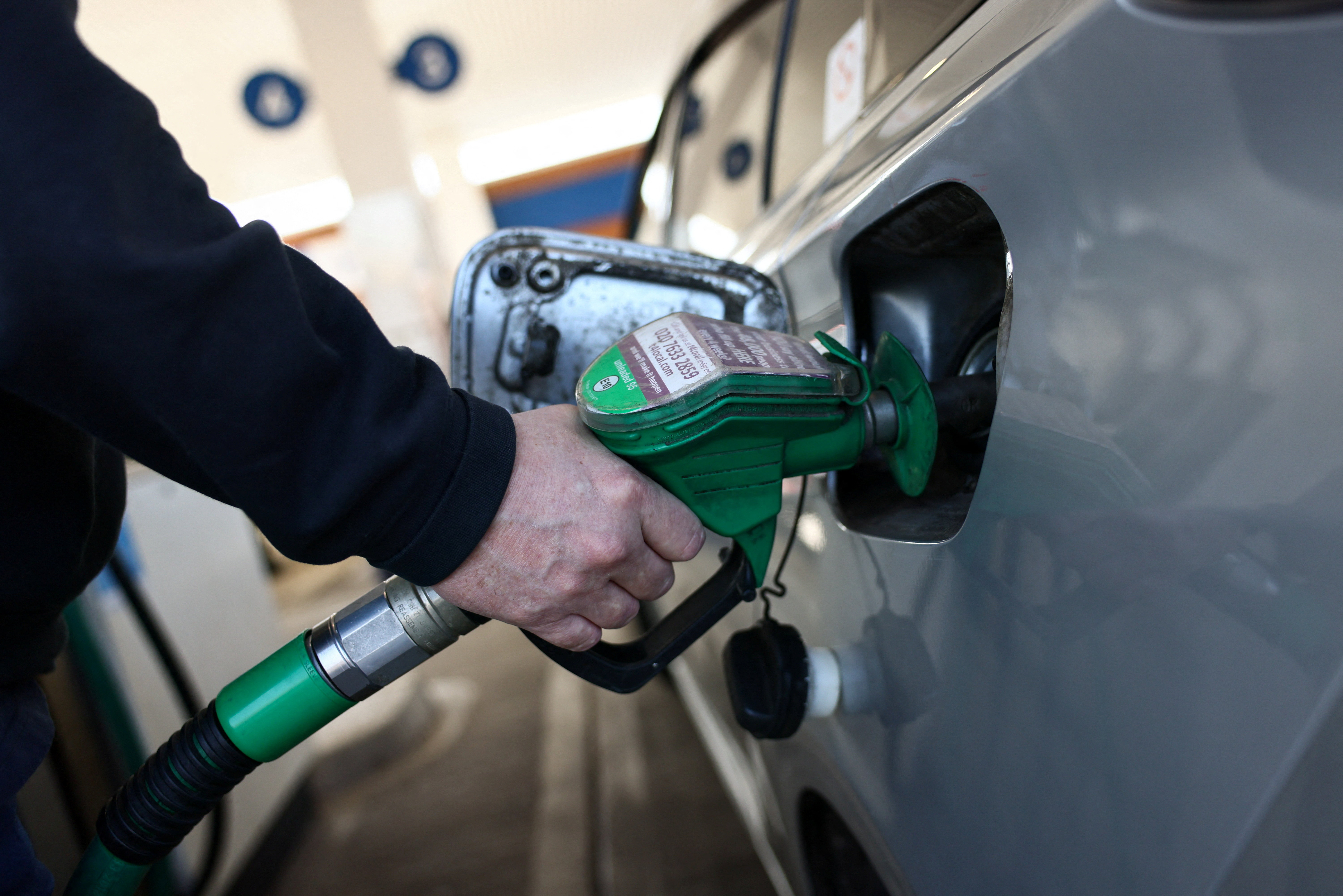 A motorist filling a car with unleaded fuel at a petrol station in London.