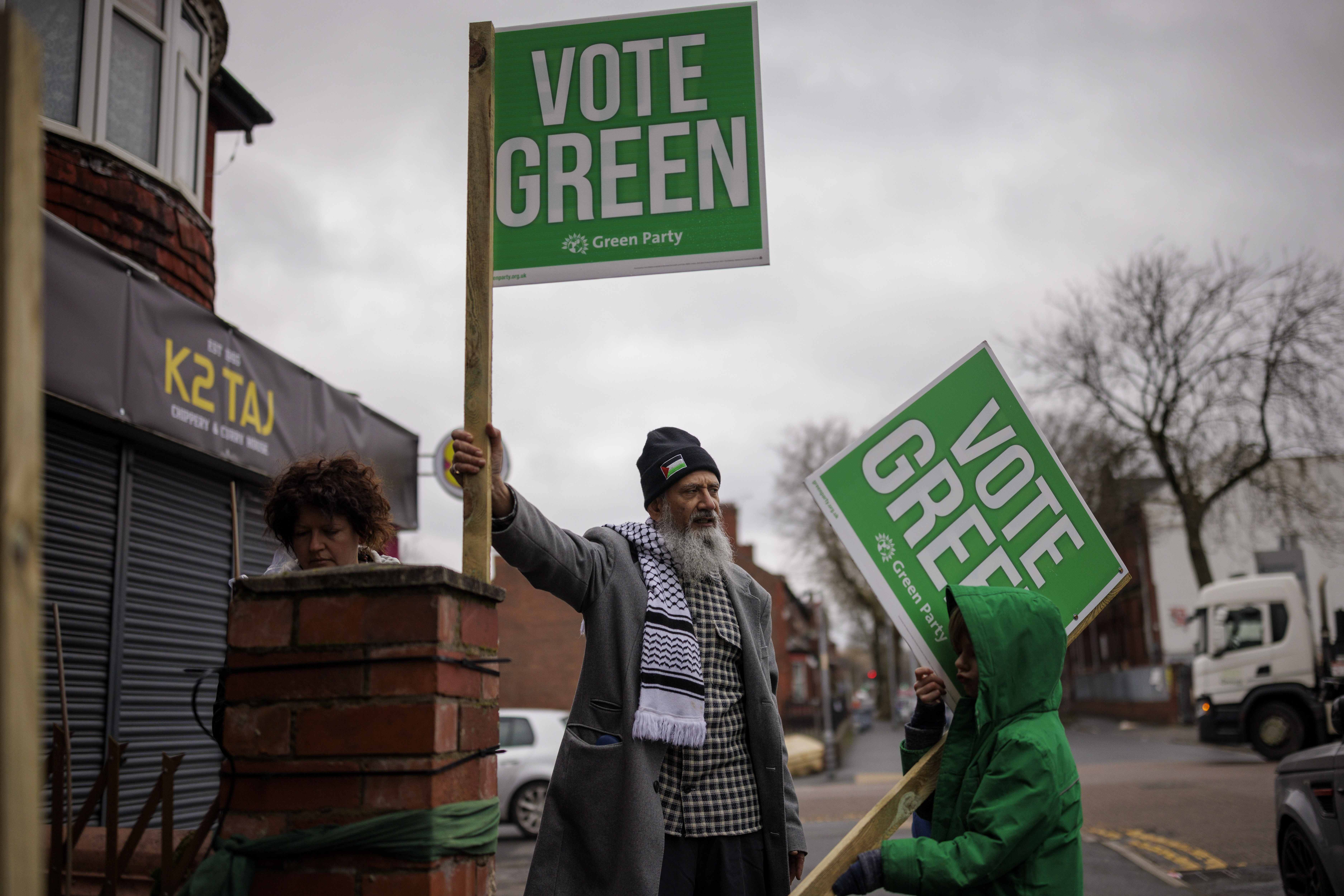 Green activists putting up "Vote Green" poster boards in Gorton.