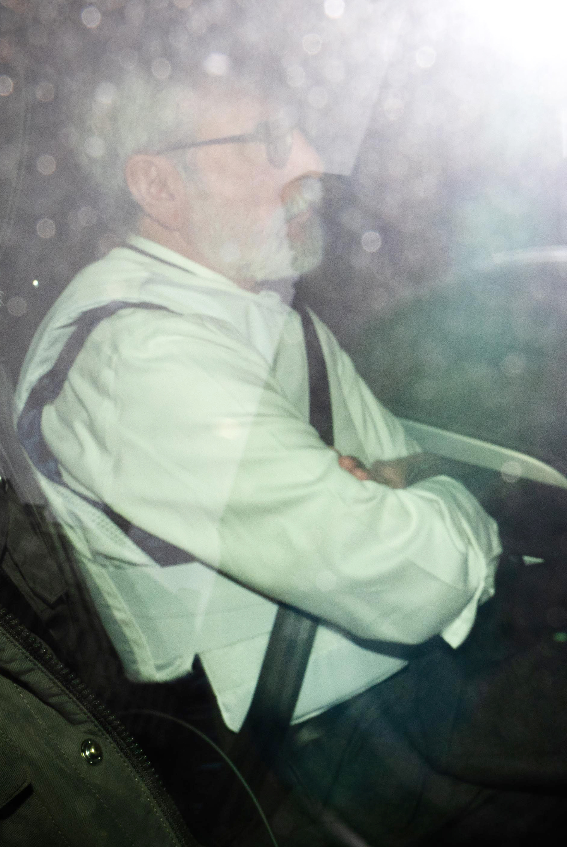 Gerry Adams, former Sinn Fein president, wearing protective equipment in a vehicle.