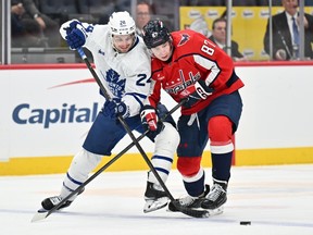 Scott Laughton of the Toronto Maple Leafs and Bogdan Trineyev of the Washington Capitals battle for control of the puck during a game earlier this season.