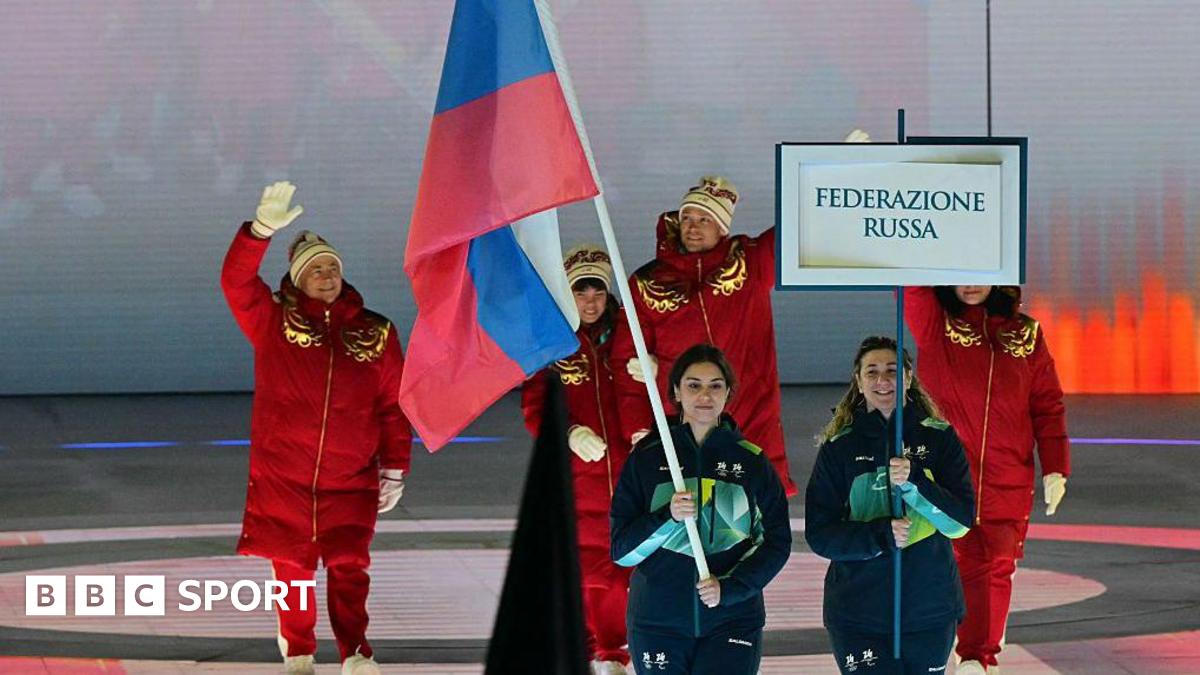 Members of the Russia team walk behind the Russia flag into the opening ceremony