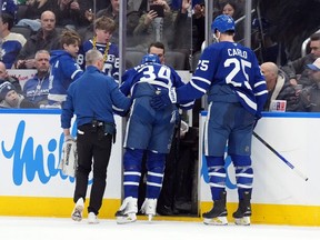 Auston Matthews is helped off the ice