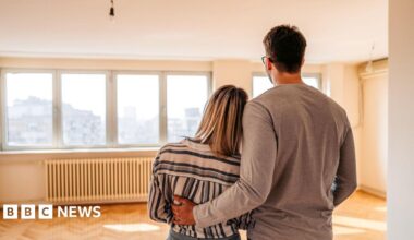 A couple looking across an empty room in a new house