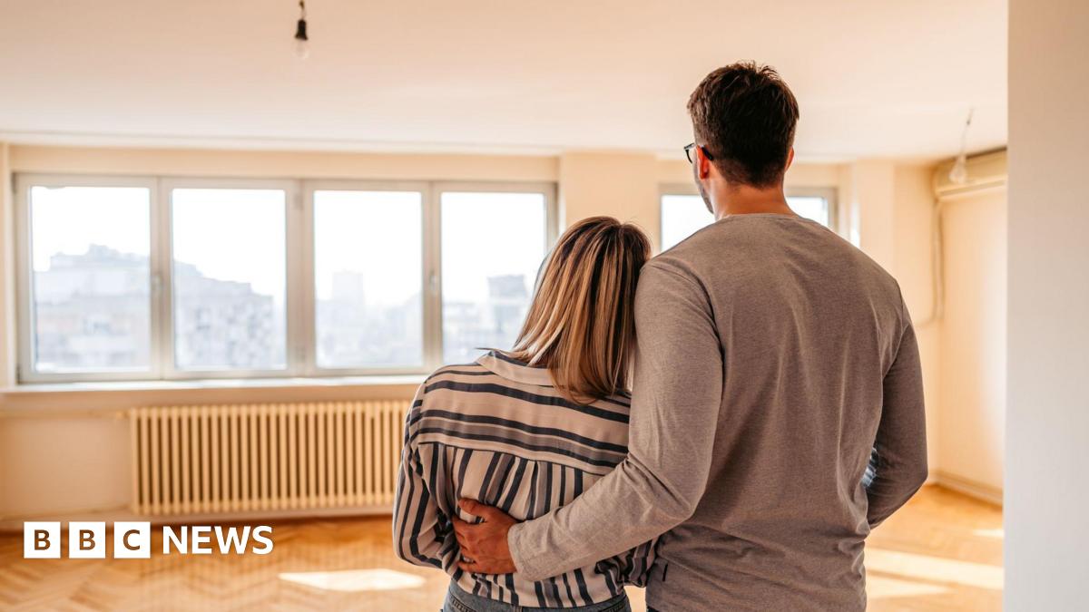 A couple looking across an empty room in a new house