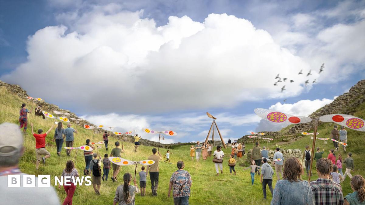 The Northern Lights shining over the Sycamore Gap at Hadrian's Wall in Northumberland, before it was illegally felled. The tree silhouette is illuminated by the pink and green light in the night sky.