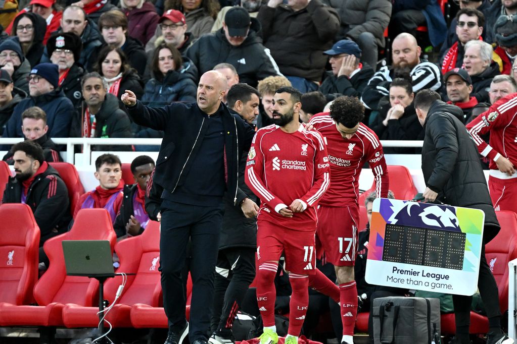 Mohamed Salah of Liverpool prepares to come onto the pitch as he interacts with Arne Slot, Manager of Liverpool, during the Premier League match between Liverpool and Tottenham Hotspur at Anfield on March 15, 2026 in Liverpool, England.