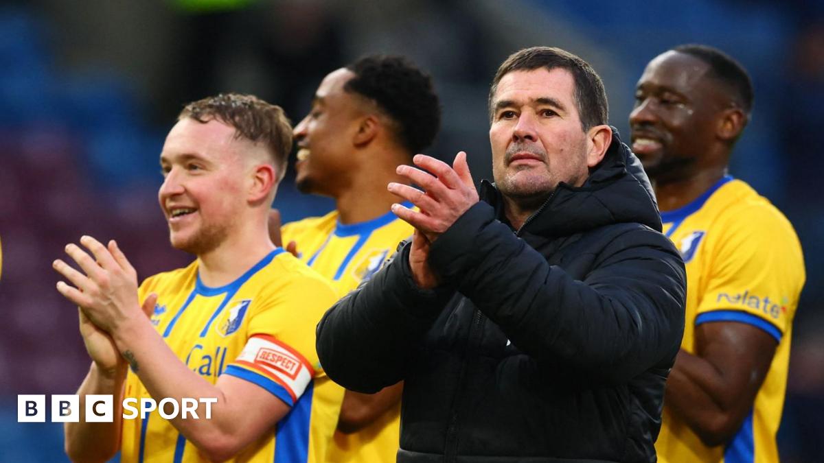 Manager Nigel Clough stands with his players and claps his hand in appreciation after Mansfield beat Burnley in the FA Cup