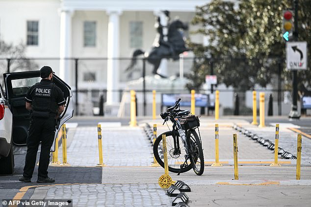 A member of the US Secret Service monitors the scene after a vehicle ran into a security barricade near the White House in Washington, DC, on March 11