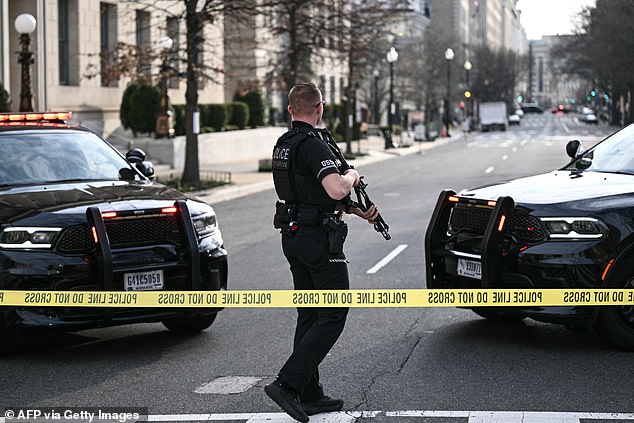 A member of the US Secret Service monitors the scene after a vehicle ran into a security barricade near the White House in Washington, DC, on March 11