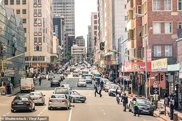 Travellers have been cautioned to remain vigilant when out and about in bustling cities like Johannesburg (pictured), with car jackings, ATM-related crime, theft and scams among common issues