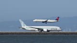 A Zipair plane is taxiing for takeoff as a Delta Airlines plane lands at San Francisco International Airport (SFO) in San Francisco, California on Aug. 31, 2024.