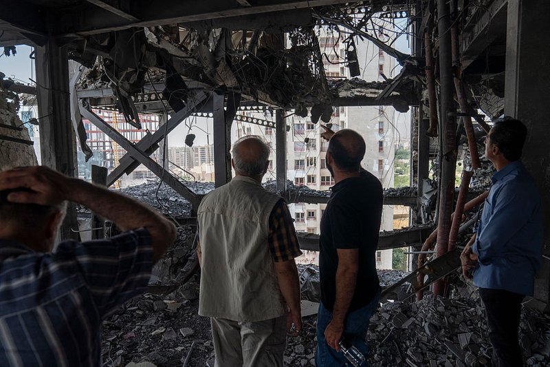 Iranians survey the damage to a residential building in Tehran, which was struck by an Israeli missile at the start of 2025's 12-day war