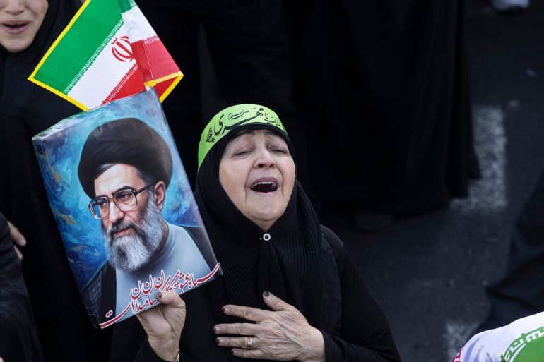 TEHRAN, IRAN - MARCH 1: A woman wails and holds a poster as thousands of people gather in Enghelab Square for a pro-government demonstration after Iranian state media confirmed the death of Ayatollah Ali Khamenei on March 1, 2026 in Tehran, Iran. Iran's Supreme Leader, Ayatollah Ali Khamenei, was confirmed killed after the United States and Israel launched a joint attack on Iran on February 28. Iran retaliated by firing waves of missiles and drones at Israel, and targeting U.S. allies in the region. (Photo by Majid Saeedi/Getty Images)