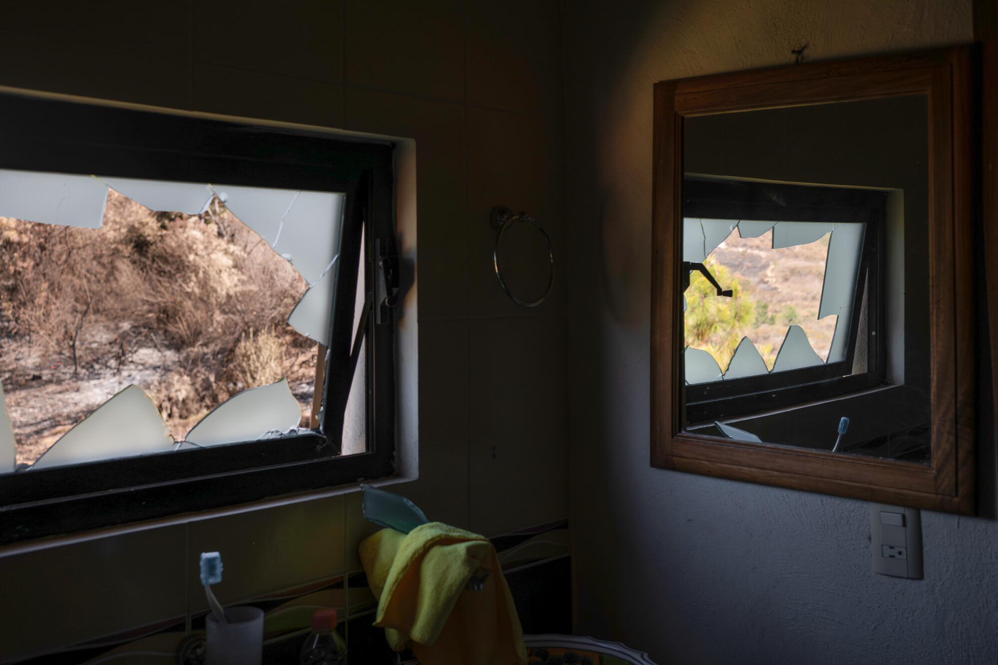 The reflection of a broken window is seen inside a bathroom