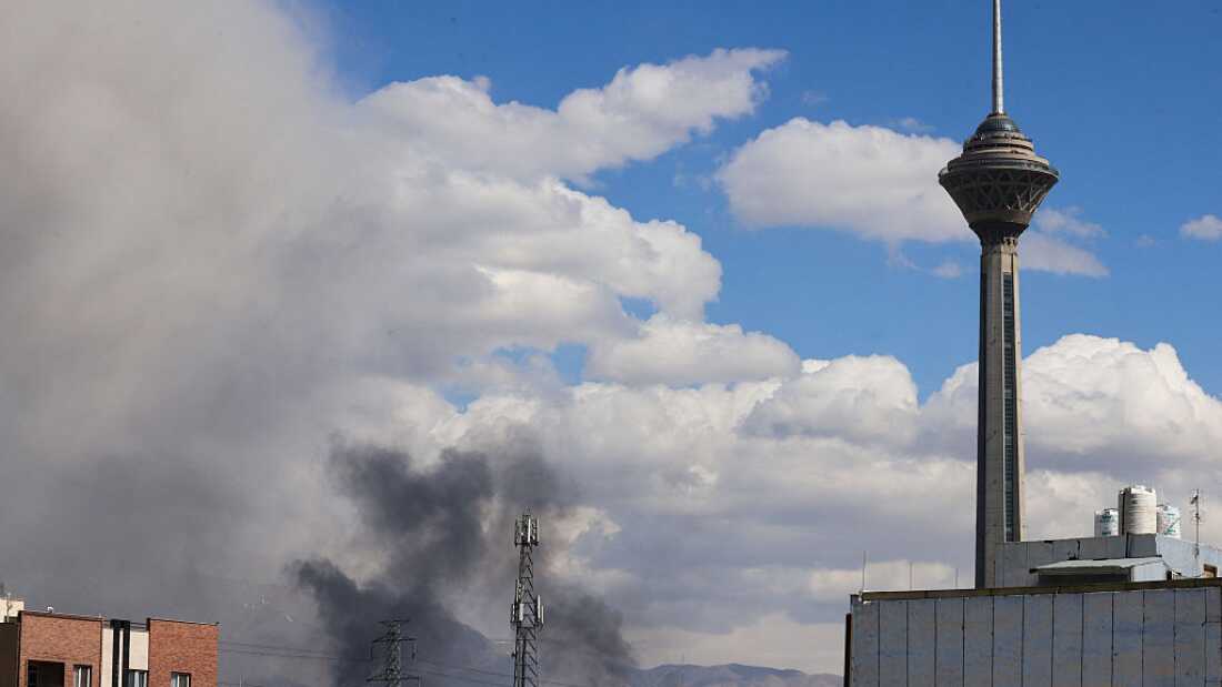 A plume of smoke rises following reported explosions in Tehran on March 1, 2026.