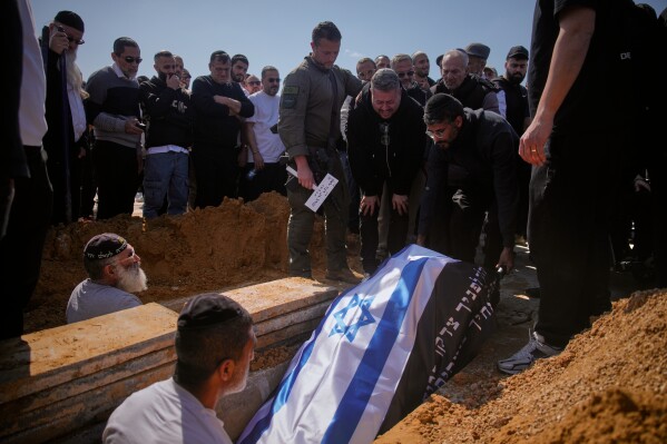Mourners lower the flag-draped bodies of Sarah Elimelech and her daughter Ronit into the grave during their funeral, a day after they were killed in an Iranian missile strike in Beit Shemesh, on Monday, March 2, 2026. (AP Photo/Ohad Zwigenberg)