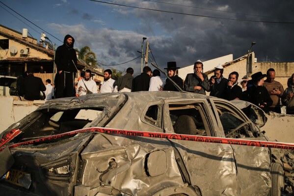 Ultra-Orthodox Jews gather at the site where several people were killed by an Iranian missile strike in Beit Shemesh, Israel Sunday, March 1, 2026. (AP Photo/Leo Correa)