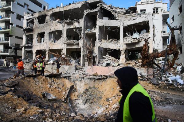 Rescue workers and military personnel survey the scene of a direct hit a day after an Iranian missile struck in Tel Aviv, Israel, Sunday, March 1, 2026. (AP Photo/Oded Balilty)