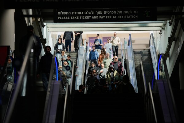 People take shelter in an underground parking garage as air raid sirens warn of incoming missiles launched by Iran toward Tel Aviv, Israel, Sunday, March 1, 2026. (AP Photo/Ohad Zwigenberg)