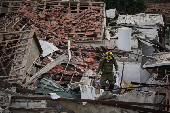An officer from Israel's Home Front Command searches through the rubble of a destroyed house after it was struck by an Iranian missile in Beit Shemesh, Israel, Sunday, March 1, 2026. (AP Photo/Leo Correa)