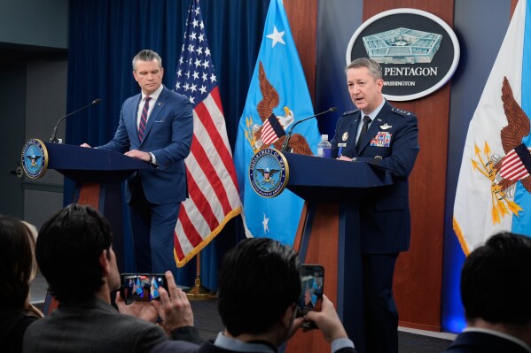 Defense Secretary Pete Hegseth and Chairman of the Joint Chiefs of Staff Gen. Dan Caine speak during a press briefing at the Pentagon, Monday, March 2, 2026, in Washington. (AP Photo/Mark Schiefelbein)