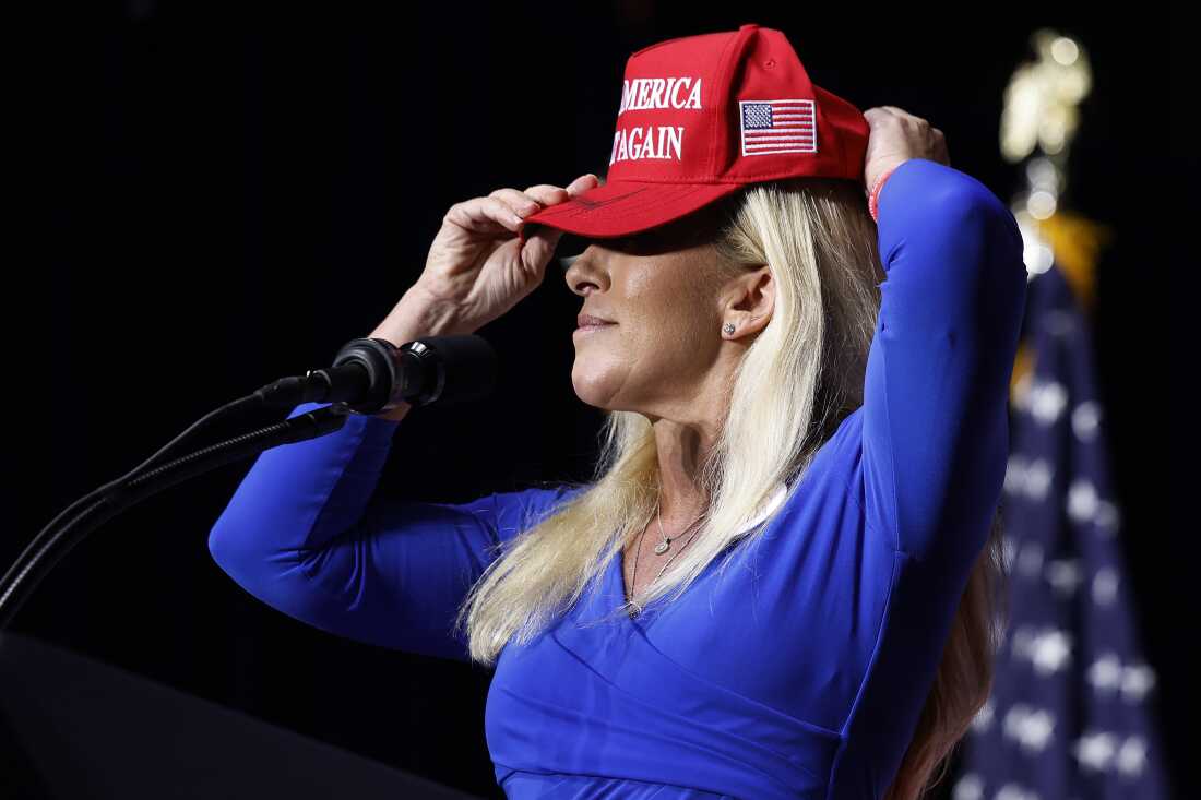 In this file photo, then-Rep. Marjorie Taylor Greene (R-GA) puts on her Make America Great Again hat while addressing a campaign rally with then Republican presidential candidate and former President Donald Trump March 9, 2024 in Rome, Georgia. After Trump ordered strikes on Iran March 1, 2026, Greene sharply criticized the president for abandoning "America First" foreign policy and his promises of "no new wars."