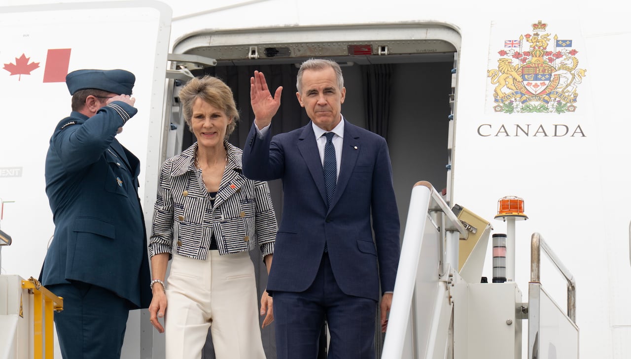 A man and woman standing outside a plane.