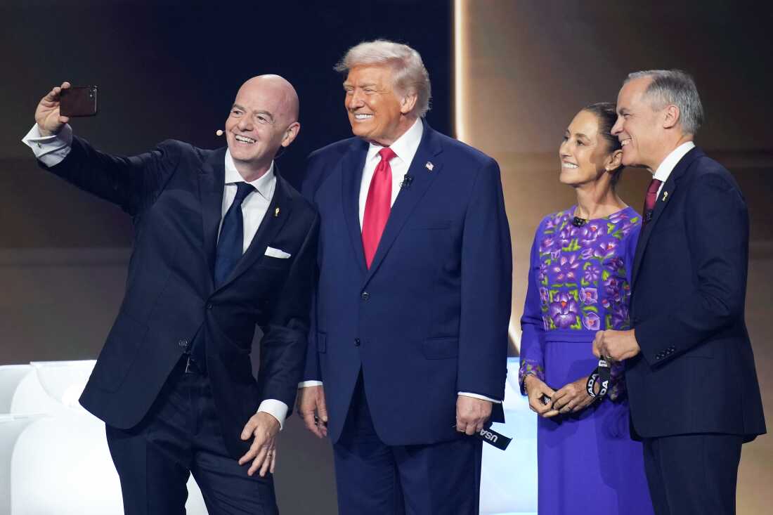 FIFA President Gianni Infantino (left) takes a selfie during the FIFA World Cup 2026 Official Draw with President Trump, Mexican President Claudia Sheinbaum, and Canadian Prime Minister Mark Carney at the John F. Kennedy Center for the Performing Arts in Washington, D.C., on Dec. 5, 2025.