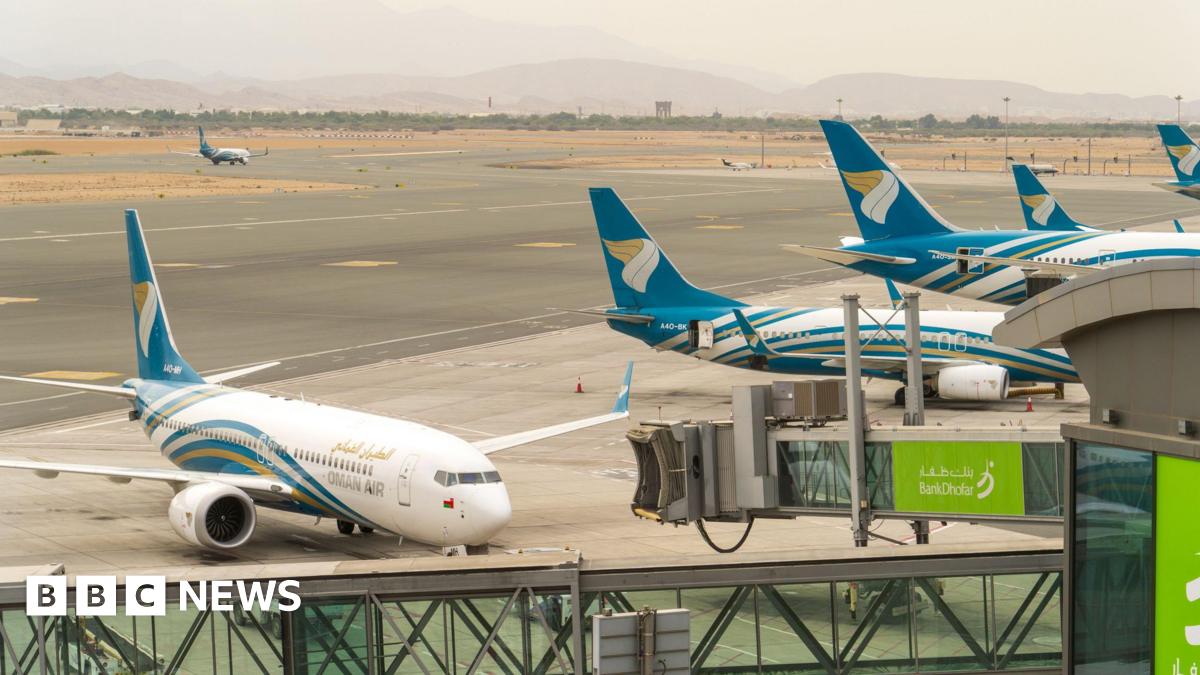 Planes with blue tails and marked "Oman Air" line up at Muscat International Airport.