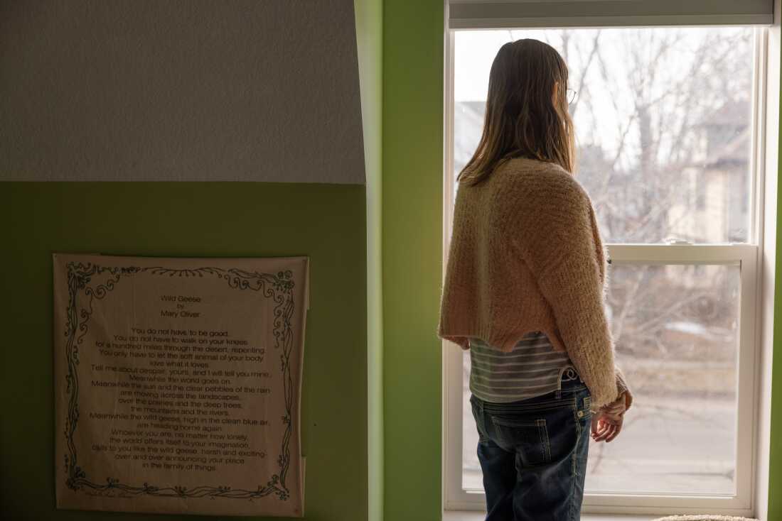 Elle poses for a portrait inside her Minneapolis home, where she says she has been surveilled by U.S. Immigration and Customs Enforcement agents during Operation Metro Surge.
