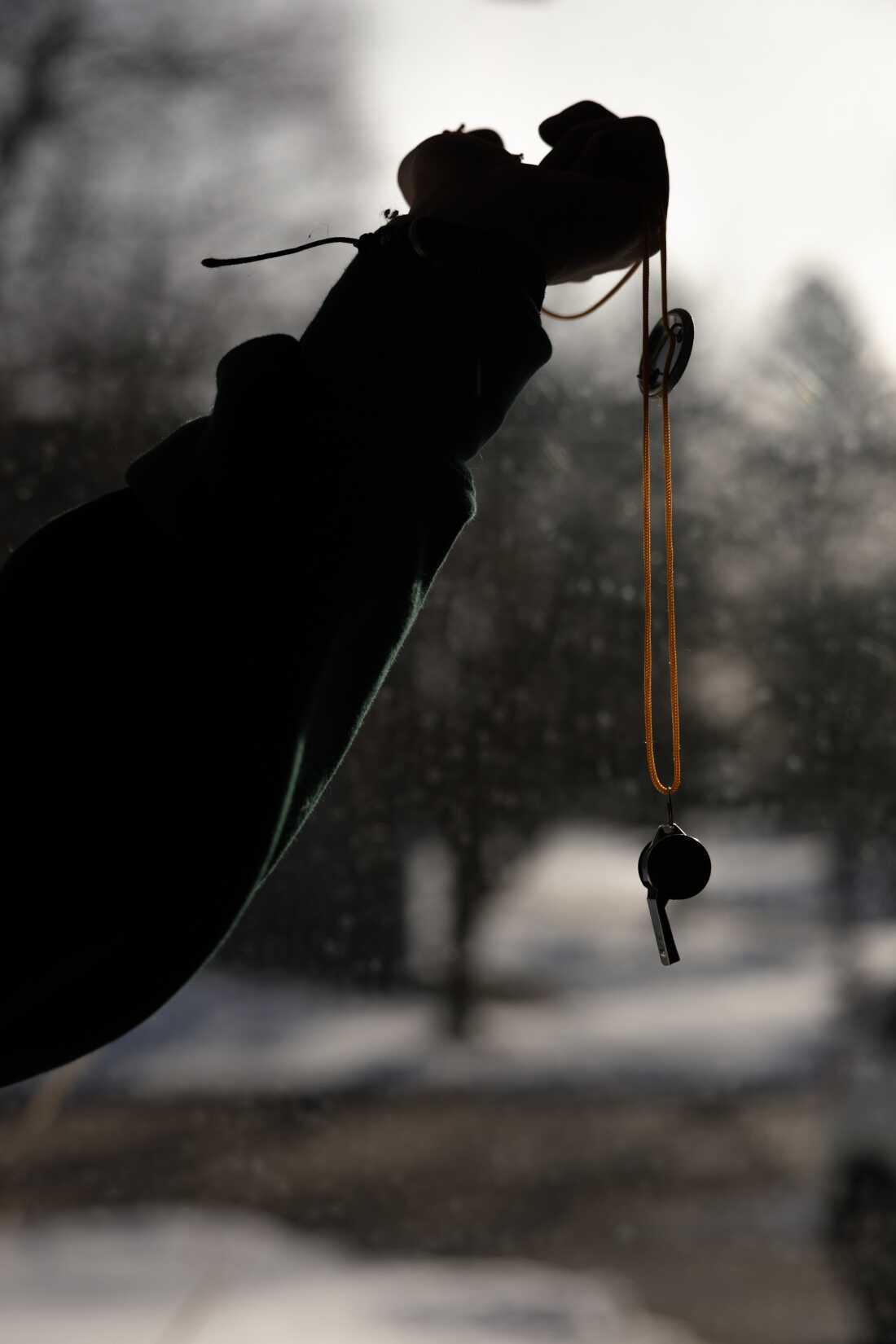 Emily poses for a portrait in her home with one of her whistles used to alert to ICE presence, Friday, Feb. 27, in Minneapolis.