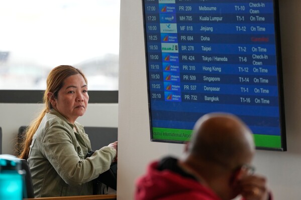 Overseas Filipino worker Norlie Lorenzana waits for updates on her cancelled flight to Kuwait at Manila's International Airport, Philippines on Monday, March 2, 2026. (AP Photo/Aaron Favila)