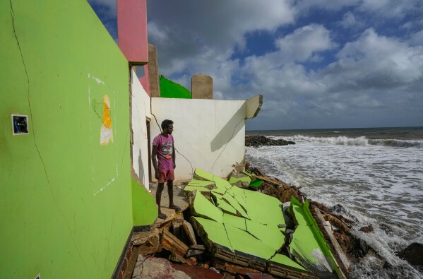 Dilrukshan Kumara looks at the ocean as he stands by the remains of his family's home in Iranawila, Sri Lanka, June 15, 2023. (AP Photo/Eranga Jayawardena, File)