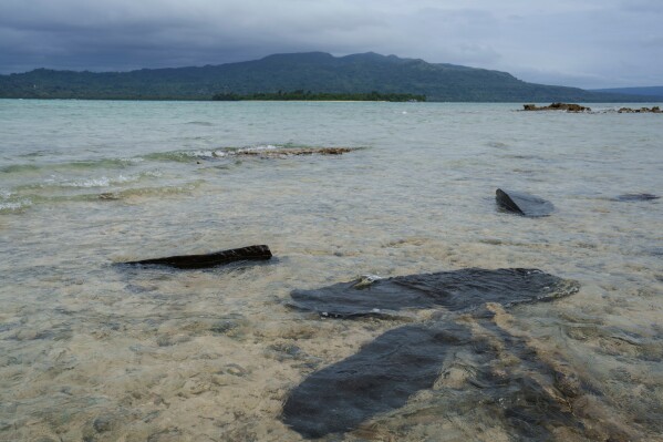 Gravestones sit submerged in water on Pele Island, Vanuatu, a country heavily affected by rising seas July 18, 2025. (AP Photo/Annika Hammerschlag, File)