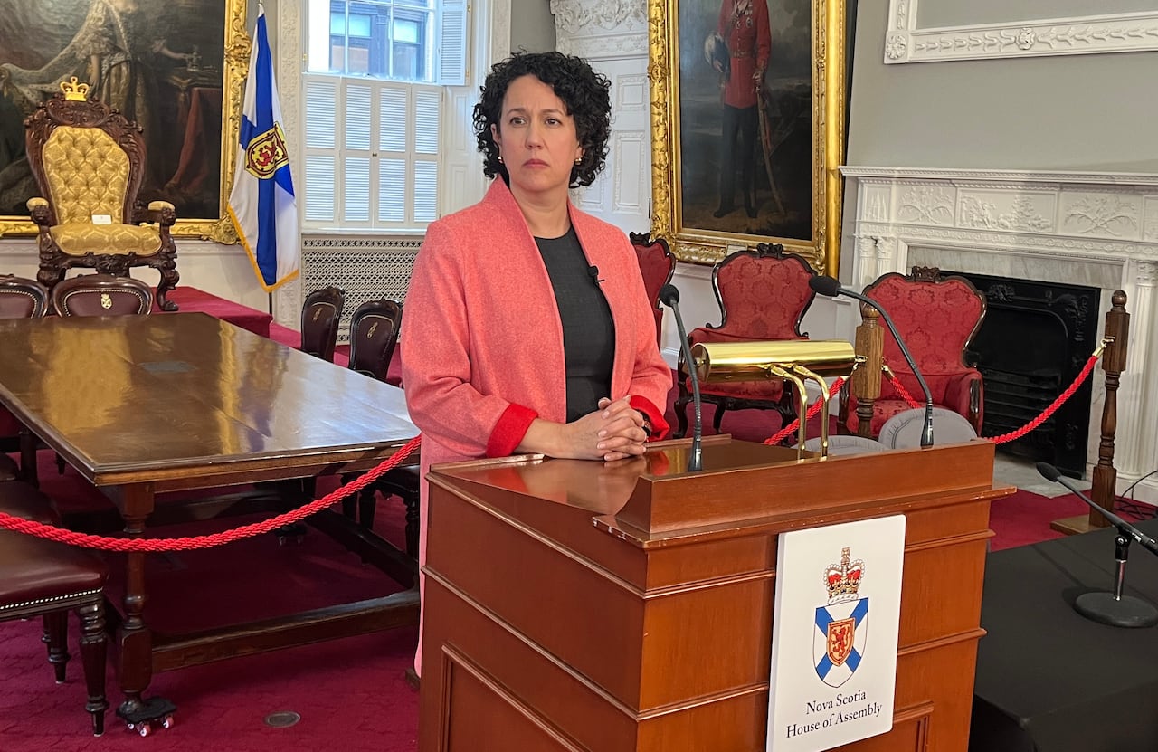 A woman stands behind a podium.
