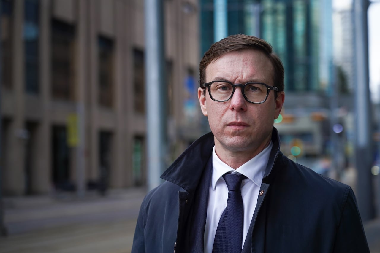 A man stands on a downtown street.
